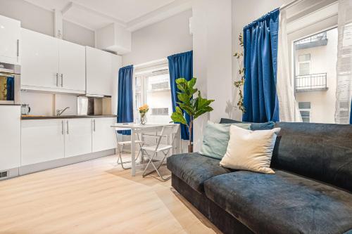 een woonkamer met een bank en een keuken bij Dinbnb Apartments I Apartment Hotel at City Centre with Roof Terrace in Bergen
