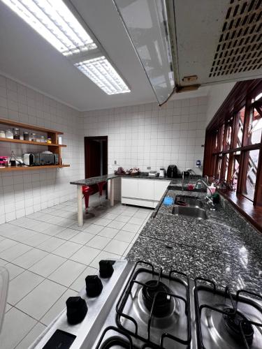 uma cozinha com um lavatório e uma bancada em Excelente quarto em Alphaville em Santana de Parnaíba