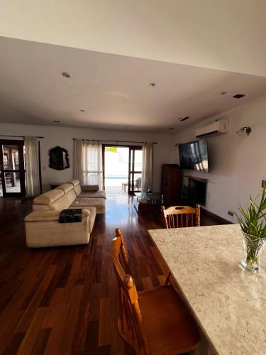 uma sala de estar com um sofá e uma mesa em Excelente quarto em Alphaville em Santana de Parnaíba