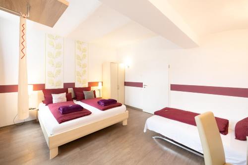 1 dormitorio con 2 camas y 2 sillas en Hotel DAH-Inn en Dachau