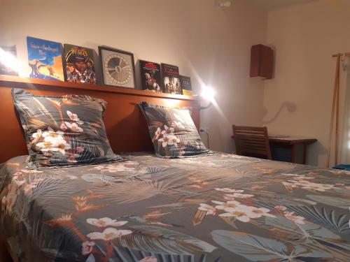 Una cama con un edredón con fotos. en Sous le Bois d'inde, en Saint-Joseph