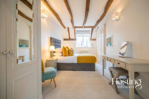 a bedroom with a bed and a desk with a desk at Stable Annex Bisham - Vibrant 1 Bed With Parking in Marlow
