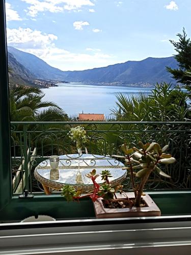 a table on a balcony with a view of the water at GREEN VILLAGE Apartment in Gornji Orahovac