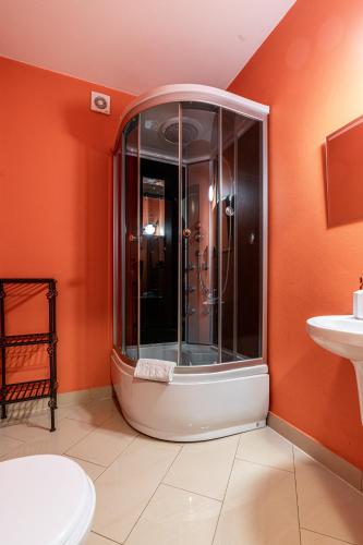 a bathroom with a shower with an orange wall at Leśny Dworek Biały Dunajec in Zakopane