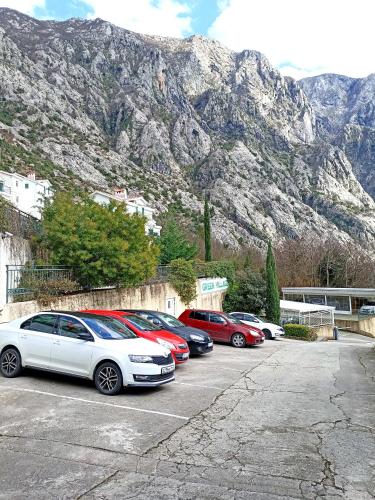 a group of cars parked in a parking lot in front of a mountain at GREEN VILLAGE Apartment in Gornji Orahovac