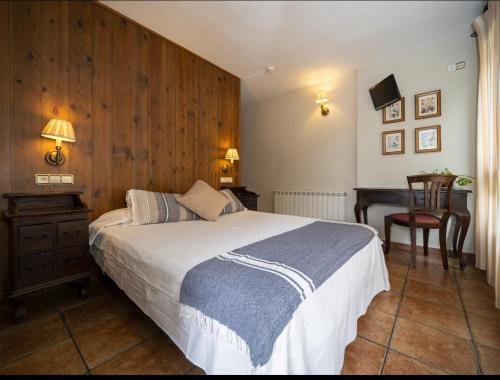 a bedroom with a bed with a wooden wall at La Fuen hostal Bielsa-Parzan in Parzán