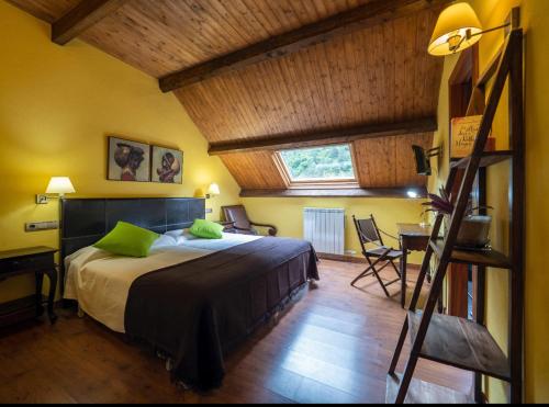 Un dormitorio con una cama con almohadas verdes y una escalera en La Fuen hostal Bielsa-Parzan, en Parzán