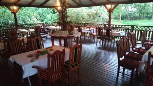 Un restaurante con mesas y sillas en una terraza. en Dworek pod Herbem, en Gądkowice