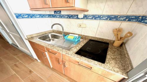 a kitchen counter with a sink and a cutting board at Welooveyou Zafiro's in Morro del Jable