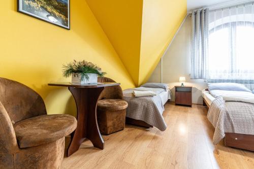 a yellow room with a table and a chair at Leśny Dworek Biały Dunajec in Zakopane