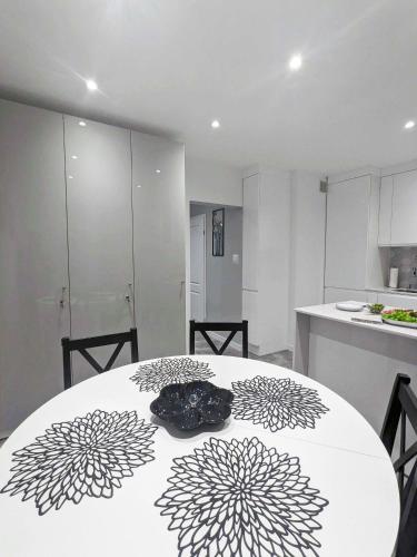 a kitchen with a white table with a black and white pattern at Misia Casa - Ultra-Modern Spotless Apartment in Historic Torun in Toruń
