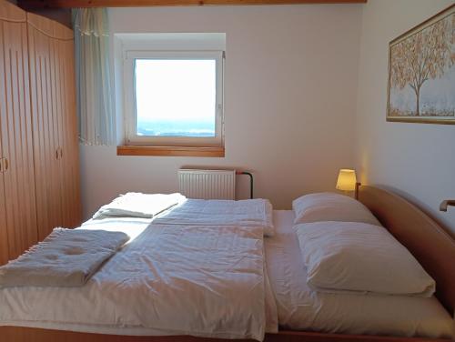 a bed with two pillows on it in a bedroom at Vineyard cottage Tilka in Novo Mesto