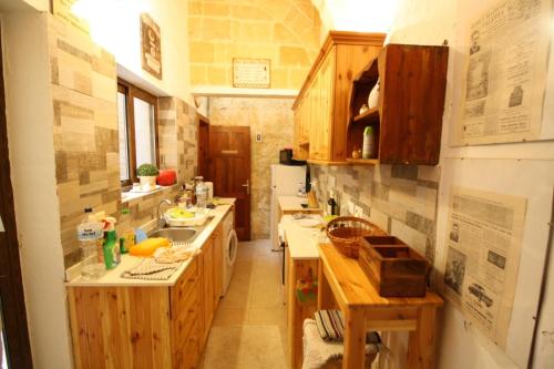 cocina grande con armarios y encimeras de madera en Old refurbished Apartment in Bormla, en Cospicua