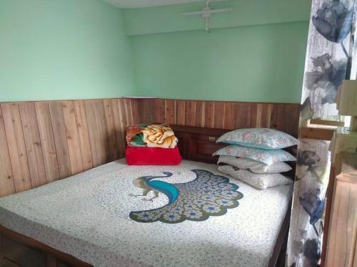 a small bed in a room with a bedsheet and pillows at Diksha Homestay in Darjeeling