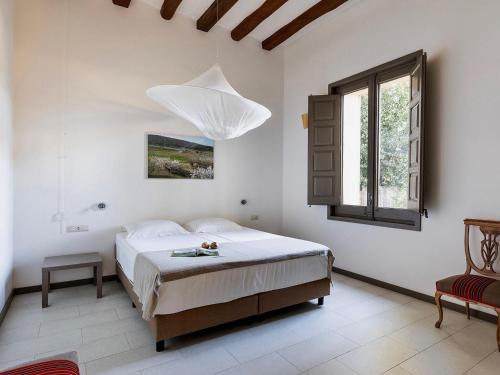 ein weißes Schlafzimmer mit einem Bett und einem Fenster in der Unterkunft Chapel Apartment with Private Terrace in La Torre de Claramunt