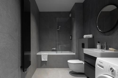 a bathroom with a shower and a toilet and a sink at Scala Apartamenty by Moderna Profit- Łąkowa 60C- Parking in Gdańsk