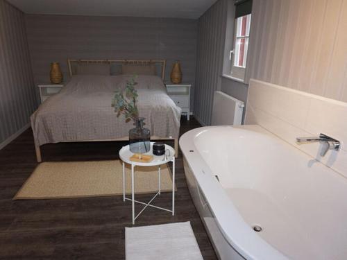 1 dormitorio con 1 cama, bañera y 1 cama en Holiday home "Schwedenhaus Bad Tabarz", en Tabarz