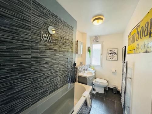 uma casa de banho com uma banheira, um WC e um lavatório. em Modern & secluded home in Frenchay em Bristol