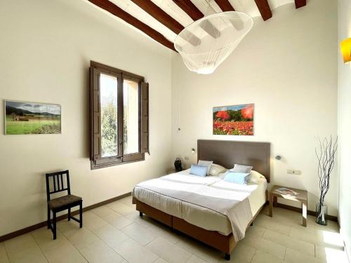 a bedroom with a bed and a window and a chair at Vilaseca apartment with private terrace in La Torre de Claramunt