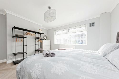 a bedroom with a large white bed with two masks on it at Spacious 3 Bedroom Modern House with Garden in Kent