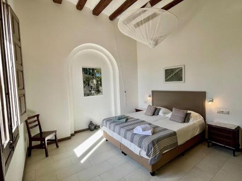 Winery apartment for two with private terrace في La Torre de Claramunt: غرفة نوم بسرير وكرسي في غرفة