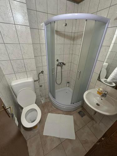 a bathroom with a shower and a toilet and a sink at Hotel Avanti in Zenica