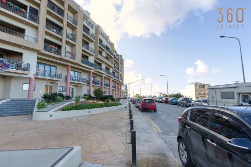 a street with cars parked in front of a building at Beautiful PENT with terrace & spectacular views by 360 Estates in Luqa