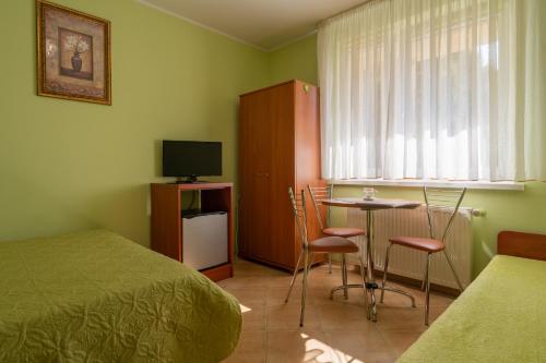 a bedroom with a bed and a table and chairs at Słoneczna Przystań (pokoje z łazienkami) in Dźwirzyno