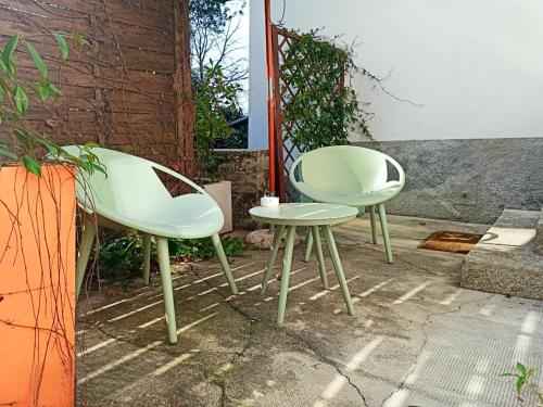 two white chairs and a table next to a building at Essentia Guest House in Faggeto Lario 