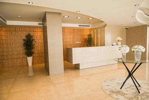 a lobby with a reception desk and a table with flowers at Villa Misk Dammam in Dammam