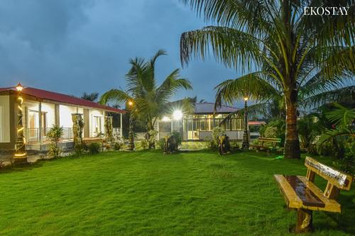 a park with a bench in front of a house at EKOSTAY - Simba Villa in Karjat
