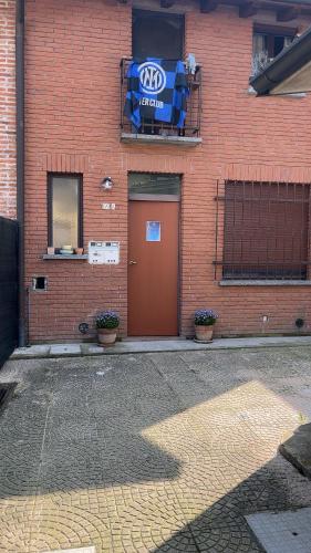 a red brick building with a door with a subaru sign at Sweet home Aurora in Trivolzio