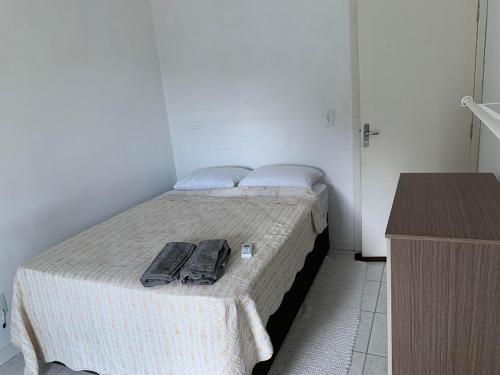 Un dormitorio con una cama con dos zapatos. en BnB Praia Mole e Barra da lagoa -piscina-churrasco, en Florianópolis