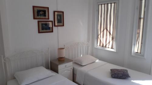 1 dormitorio con 2 camas y ventana en Motivi cottage en Saints Constantine and Helena