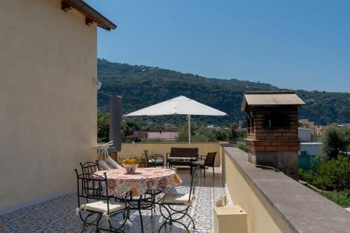 d'une table et de chaises sur un balcon avec un parasol dans l'établissement Sorrento Realty Holidays Pinnidys House, à Sorrente