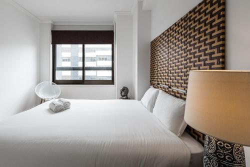 1 dormitorio con cama blanca y ventana en GuestReady - Mystic Subdual, en Oporto