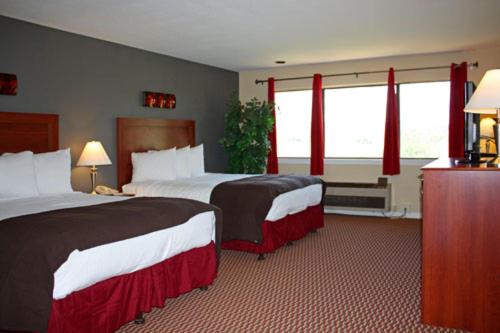 Habitación de hotel con 2 camas y cortinas rojas en Shenandoah Inn, MAJOR CREDIT CARDS REQUIRED for check in, en Plymouth