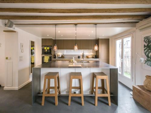 une cuisine avec un grand îlot et deux tabourets de bar dans l'établissement Saint-Germain-Des-Près Love Story, à Paris