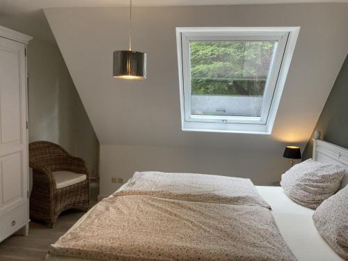 Schlafzimmer mit einem Bett und einem Fenster in der Unterkunft Ferienwohnung Kurparkhaus 19c Wyk in Wyk auf Föhr