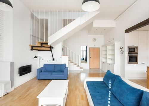 sala de estar con sofá azul y mesa en Sky Garden Premium Penthouse, en Varsovia