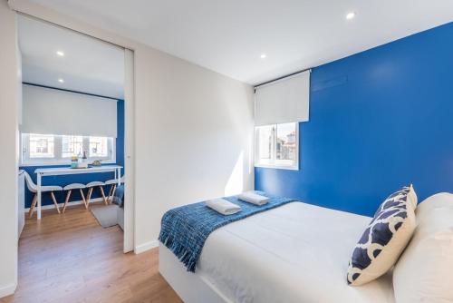 Dormitorio azul con cama y escritorio en GuestReady - Theater Apartment en Oporto