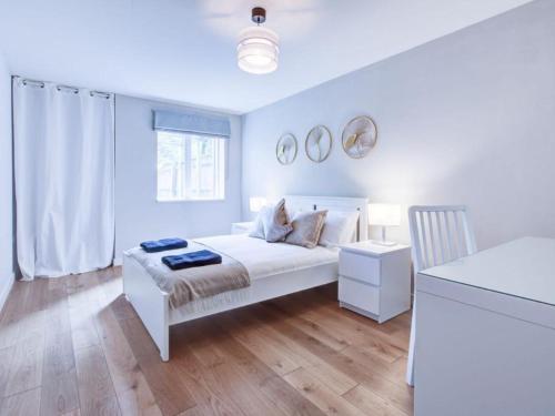 a white bedroom with a bed and a window at Light & Airy - Free Parking - Wonderful Location - Sleeps 5 in London