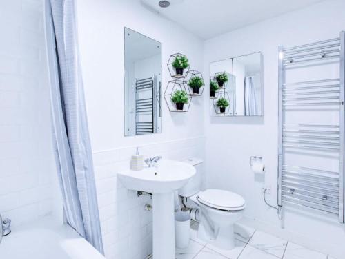 a white bathroom with a sink and a toilet at Light & Airy - Free Parking - Wonderful Location - Sleeps 5 in London