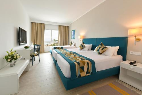 a hotel room with two beds and a television at Blue Beach Golf and Spa in Monastir