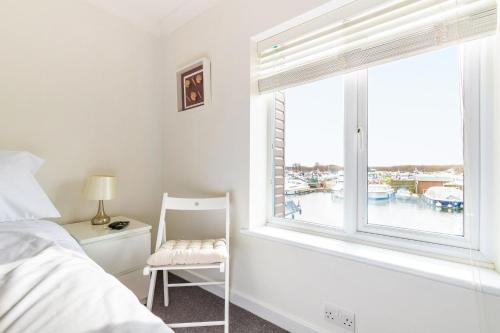 a bedroom with a bed and a chair and a window at Kingsmere in Horning