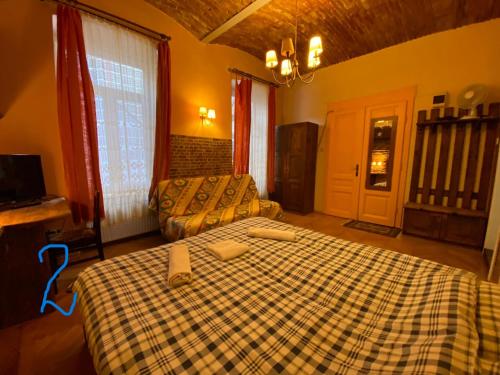 a bedroom with a bed with a checkered blanket at Old Town Studio in Braşov