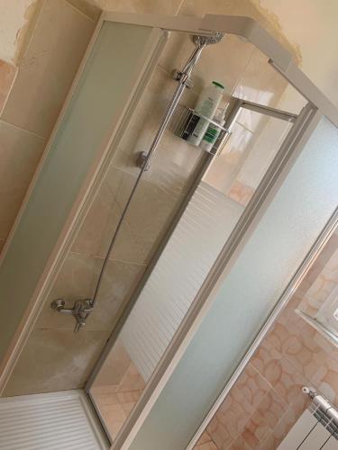 um chuveiro com uma porta de vidro na casa de banho em Skyy guest house em Pisa