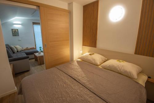 1 dormitorio con cama con espejo y sofá en Vineyard cottage Majolka en Novo Mesto