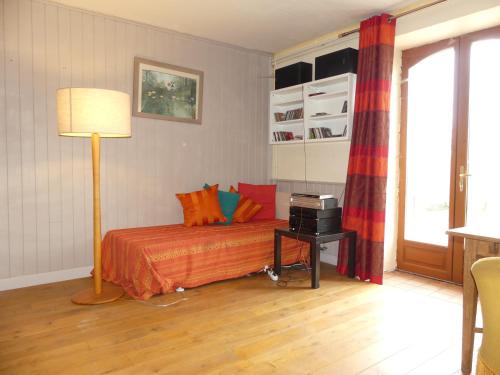 - une chambre dotée d'un lit avec des draps orange et une lampe dans l'établissement VIC-de-CHASSENAY, 