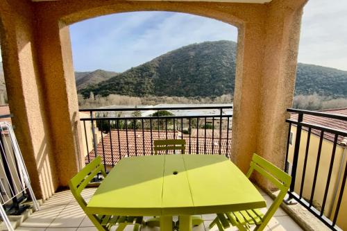 - une table verte sur un balcon avec vue sur la montagne dans l'établissement Les Naïades H40- 2 bedrooms for 6 people !, à Avène